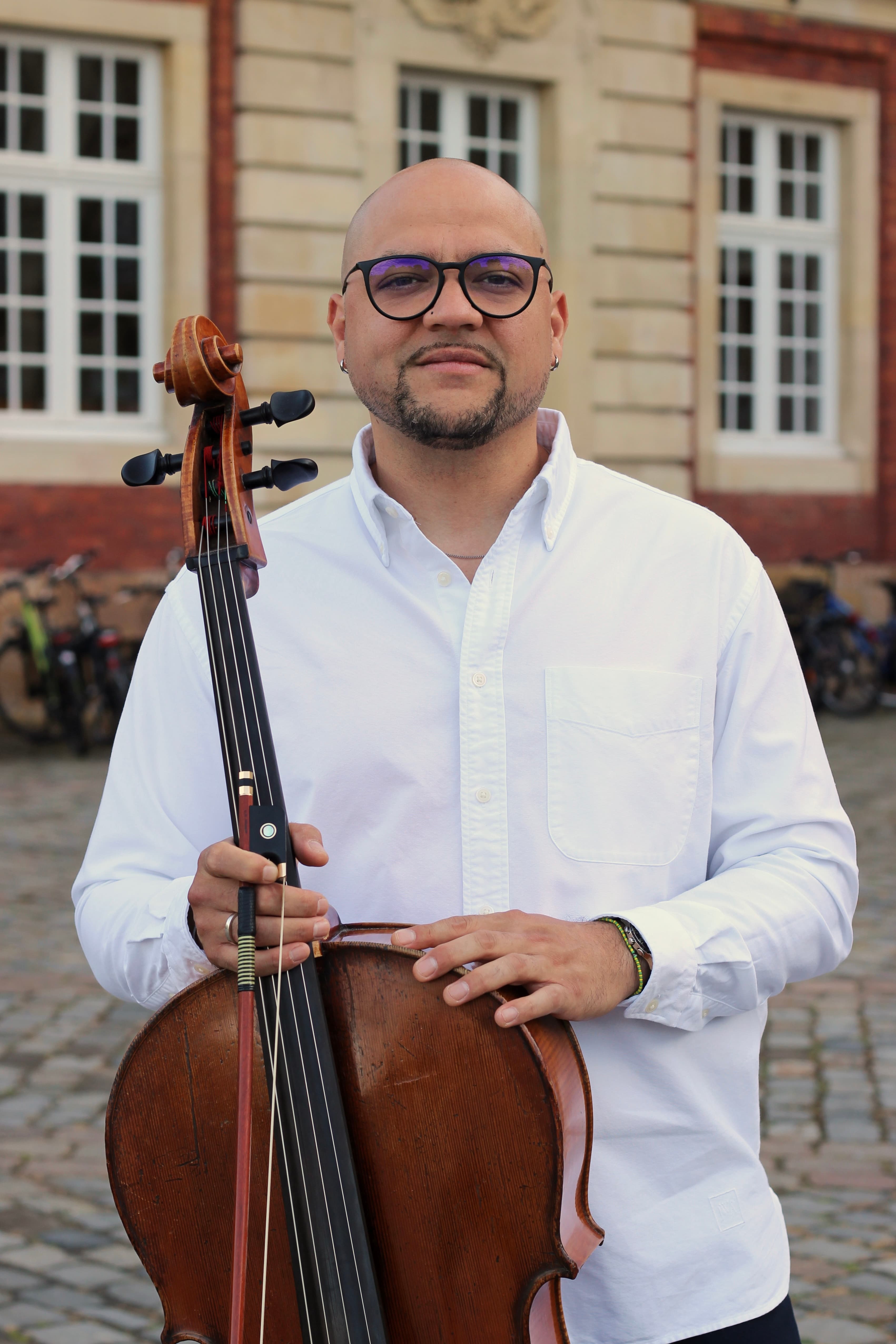 Carlos Ferrer mit seinem Cello vor dem Schloss Münster